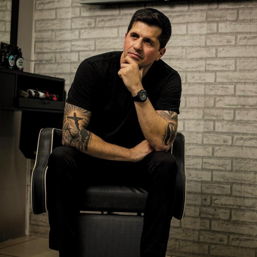 Jonatas Cirolini sentado na cadeira da barbearia Stylo